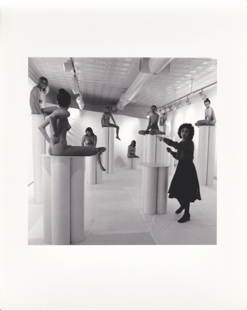 Installation view of 1976 show Women in Glasses showing artist Cyncha Jeansonne (then known as Cyndi Ketchum) with nude models on pedestals with eye glasses.